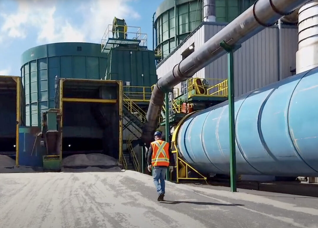 Man walking by a wood pellet mill