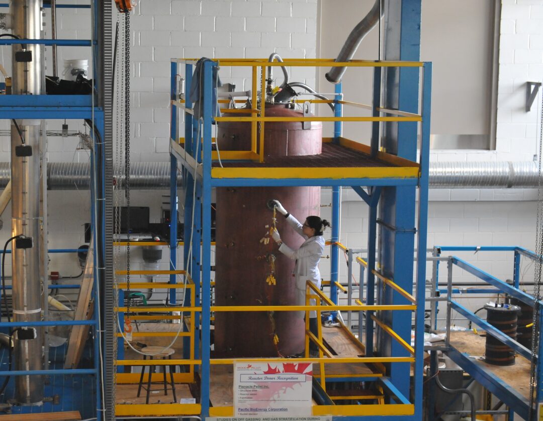 A person doing research in a lab but a large machine.