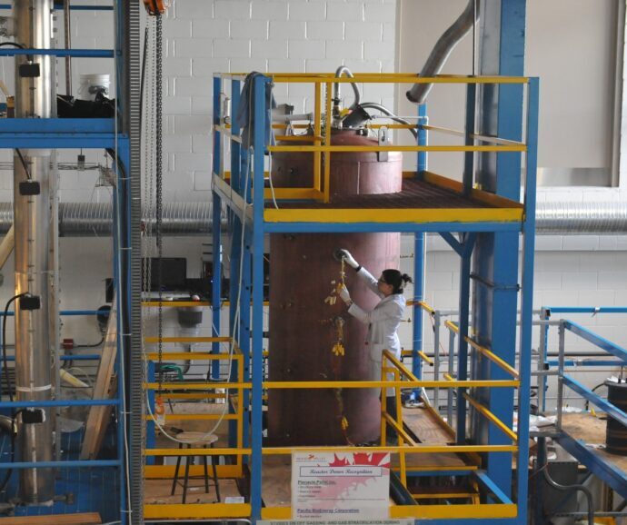 A person doing research in a lab but a large machine.