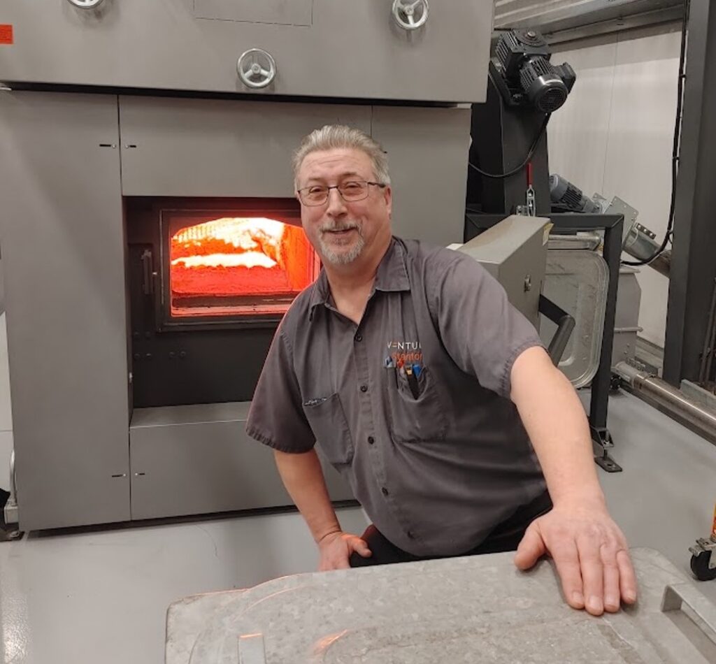 Man in front of a pellet boiler.