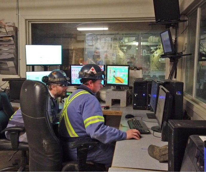 people looking at screens in a pellet mill