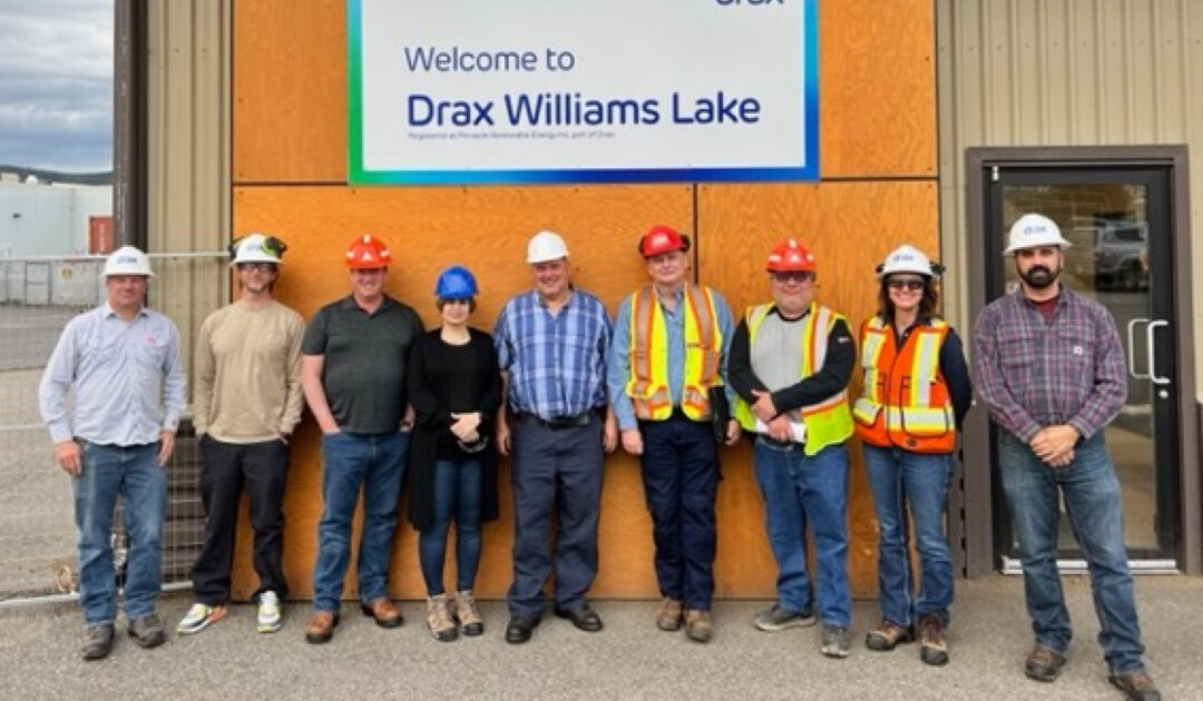 picture of people in safety gear in front of a pellet mill sign