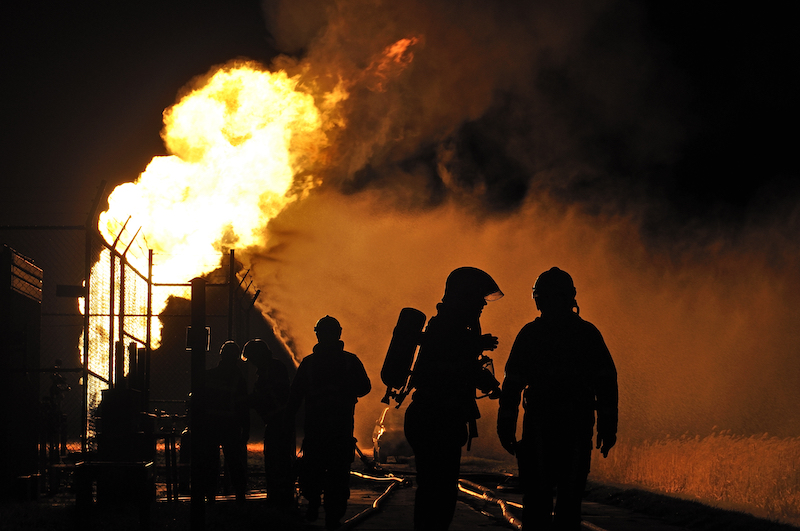 People in front of a fire from a gas explosion